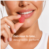 Woman holding a pink Creatine Femme+ gummy near her mouth.