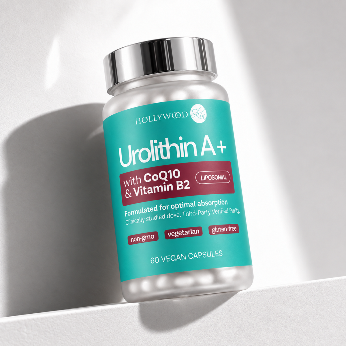 Urolithin A+ glass bottle with silver cap on a pale ledge.
